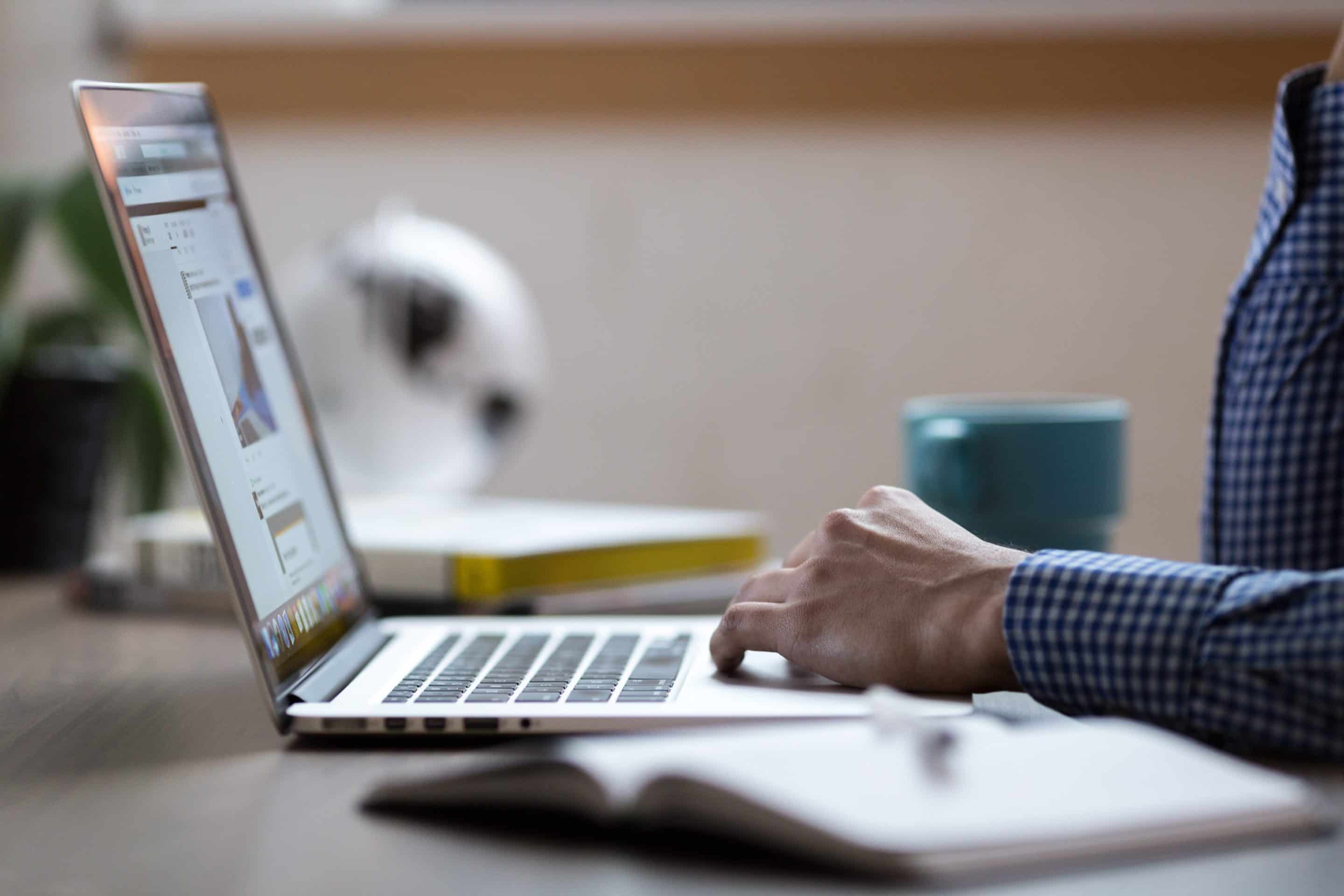 Designer using laptop and pen from above